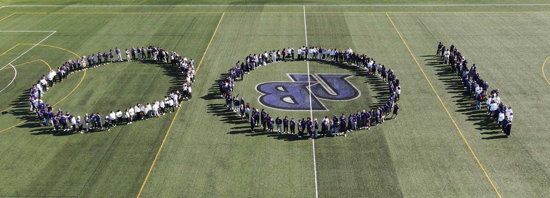 aerial photo of students on the field forming the numbers 100